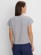 Cream & navy blue top with horizontal stripes made of small, textured diamond shapes. Features short, relaxed sleeves.
