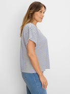 Off-white top with navy horizontal diamond stripes. Short-sleeved, loose fit.