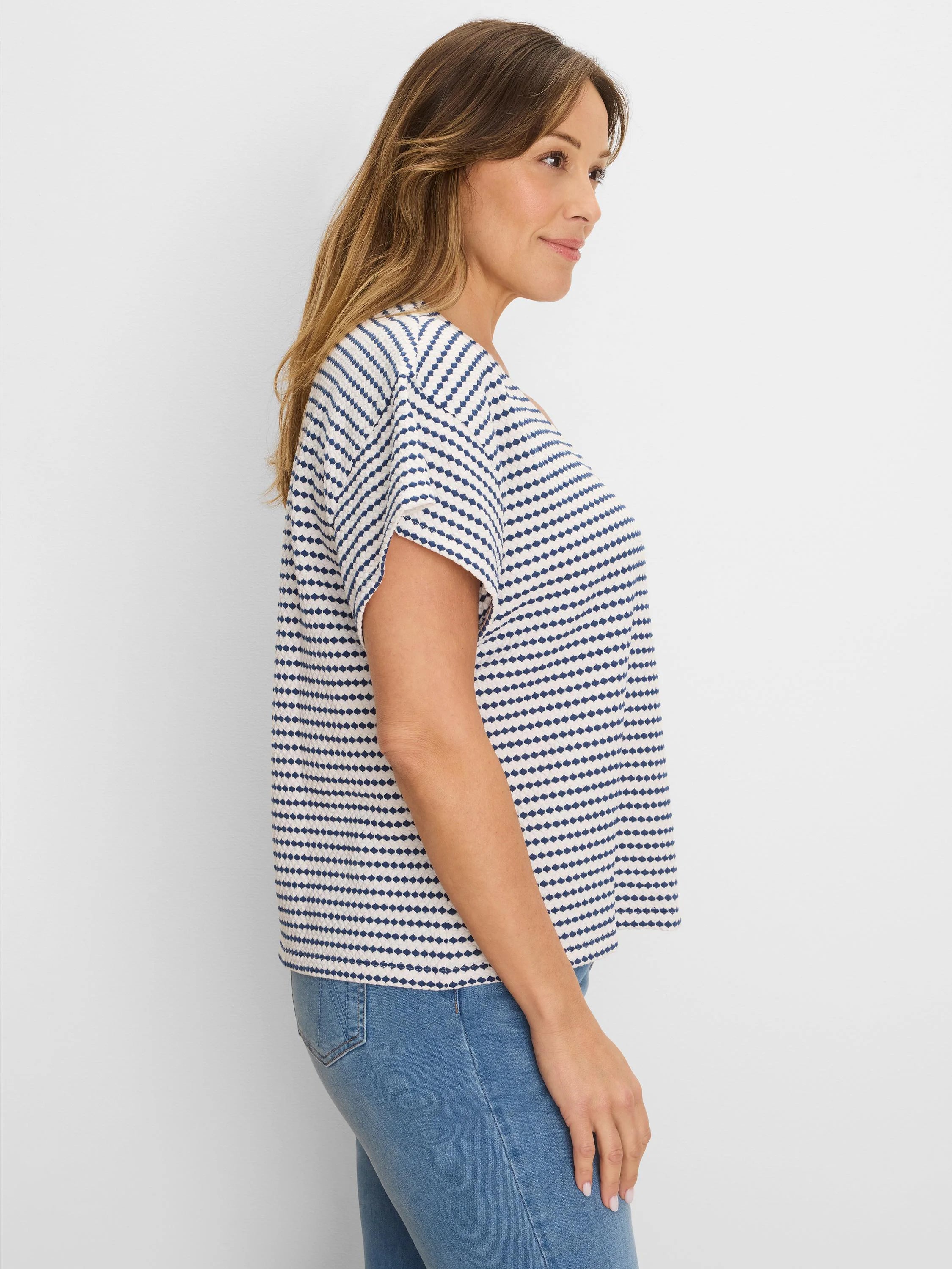 Off-white top with navy horizontal diamond stripes. Short-sleeved, loose fit.