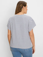 Off-white short-sleeve top with textured navy diamond horizontal stripes.