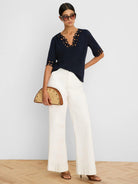 Navy V-neck top with scalloped cut-out details on the neckline and elbow-length sleeves.