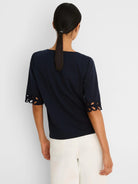 Navy blue top with rococo-style cut-out details on the elbow-length sleeve cuffs.
