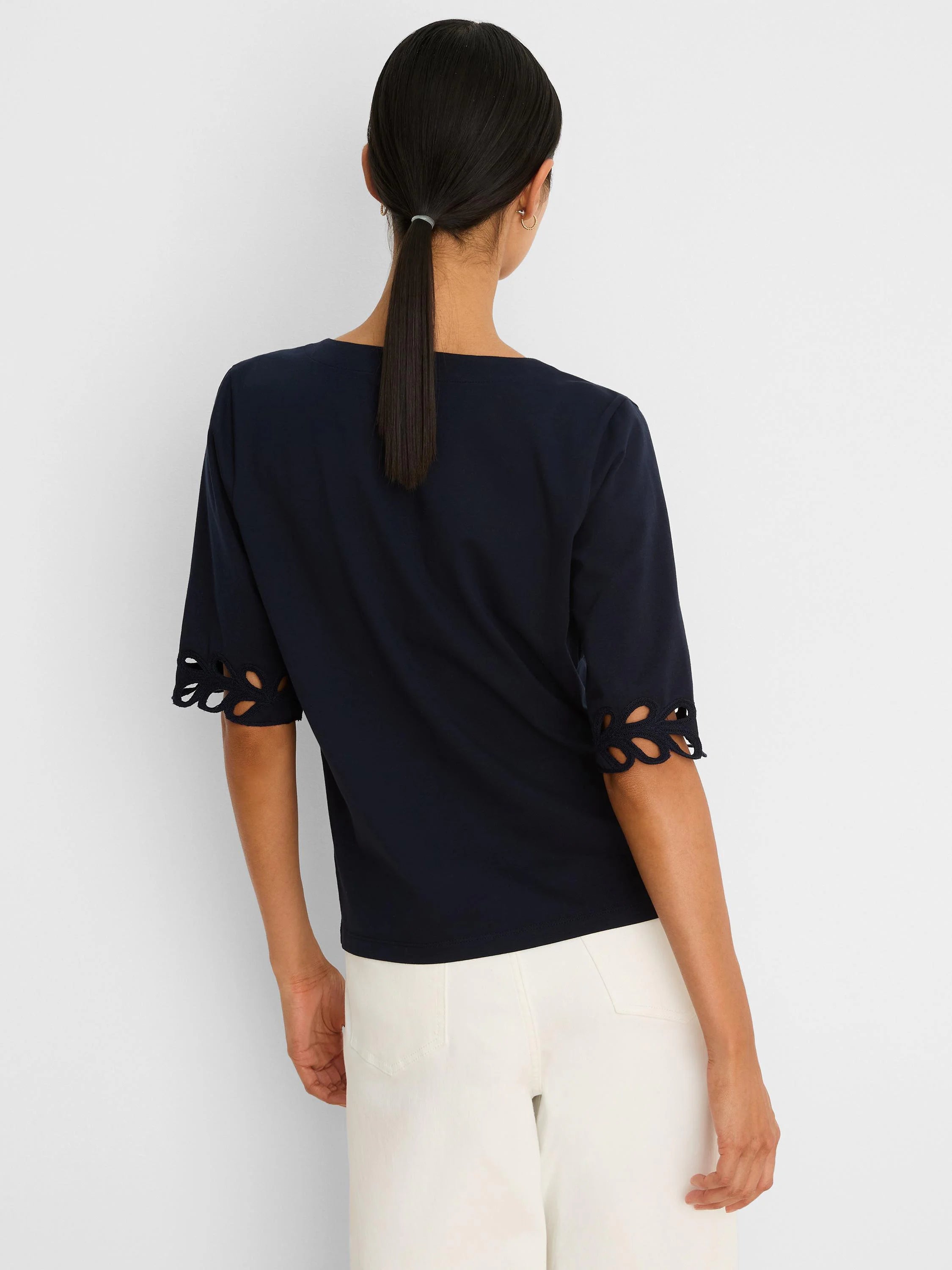 Navy blue top with rococo-style cut-out details on the elbow-length sleeve cuffs.