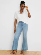 White top with a scalloped cut-out V-neck and short sleeves.