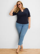 Navy top with ornate, scalloped cut-out edges around the neckline and short sleeves.