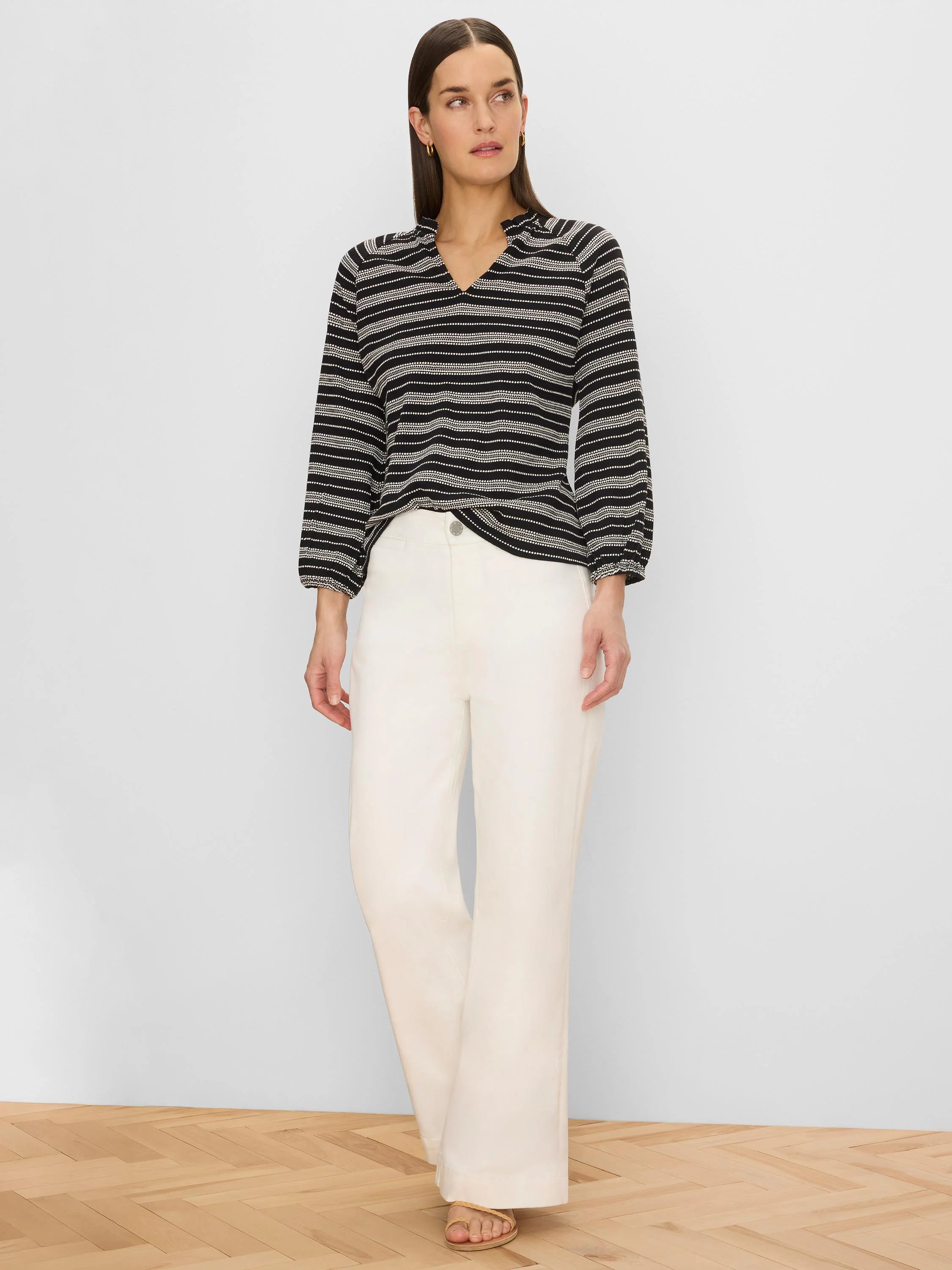 Black knit top with white horizontal dotted stripes, V-neck with ruffled collar, and 3/4 elastic cuff sleeves.