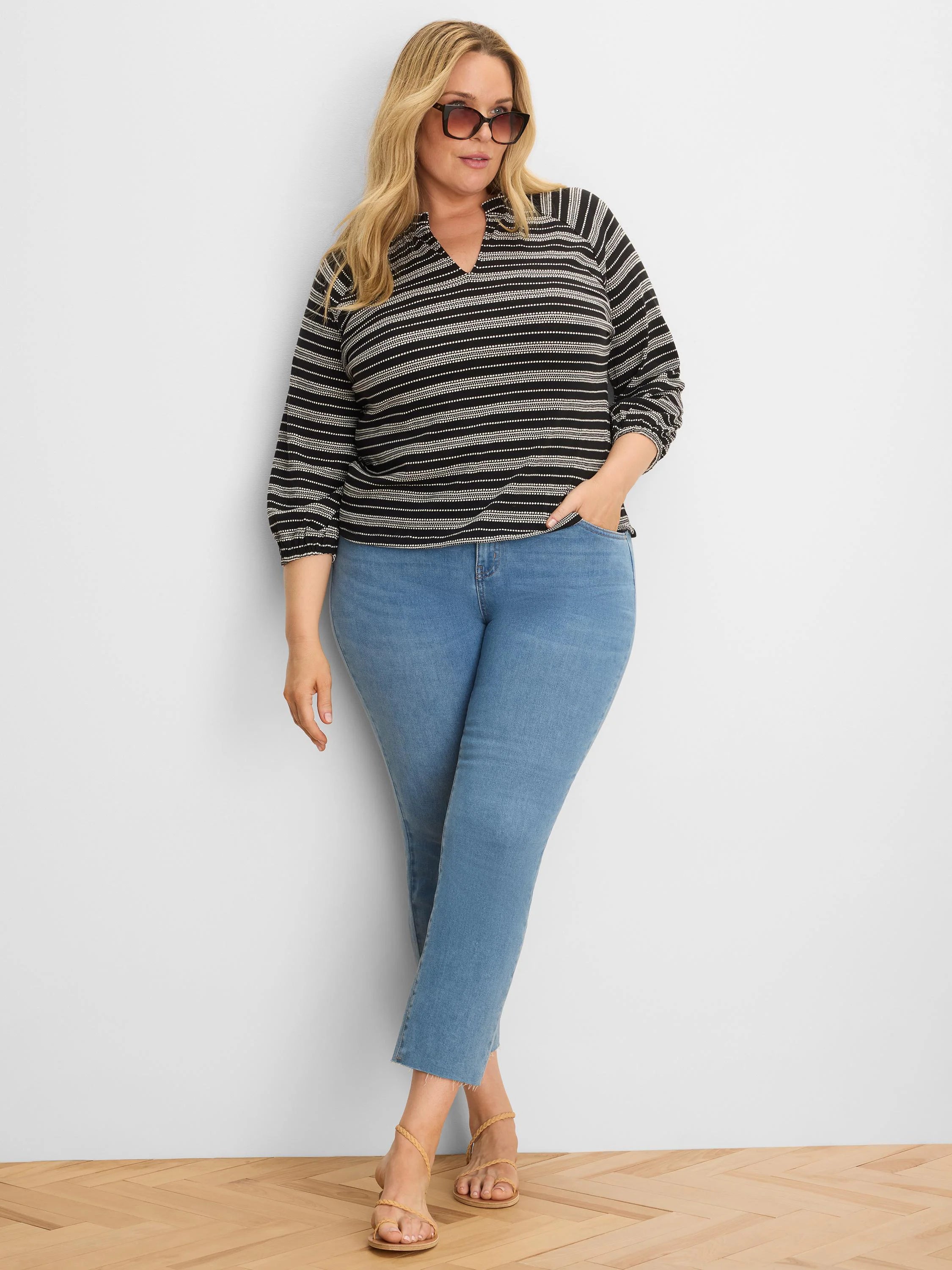 Black knit top with textured off-white horizontal stripes, a collared V-neck, and 3/4 sleeves.