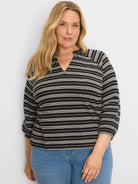 Black and white knit top with mixed horizontal stripes (solid & dotted), a split V-neck, and 3/4 sleeves.
