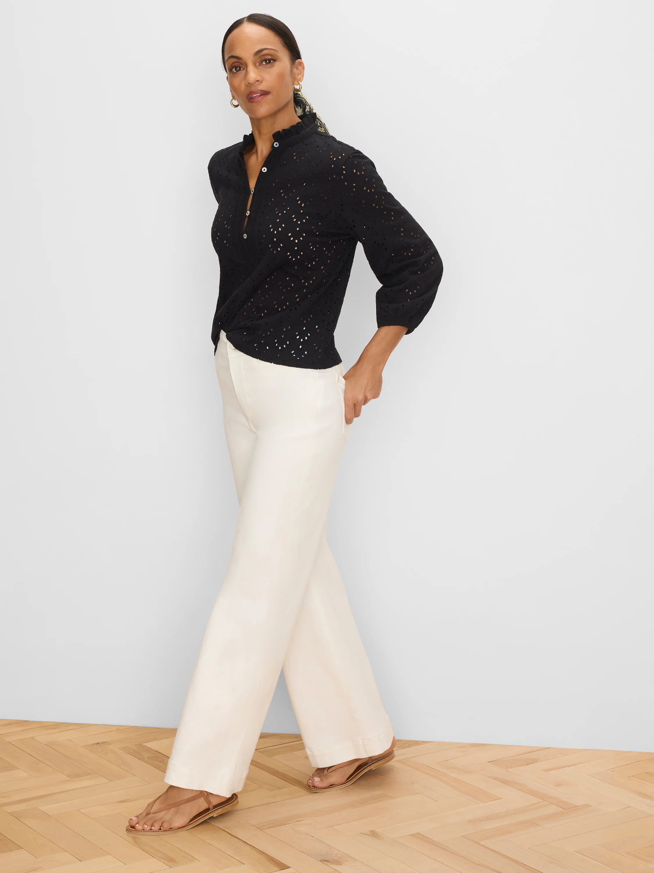 Black eyelet top with a ruffle neck and 3/4 length sleeves.
