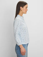 Light blue eyelet top with a ruffled stand collar and 3/4 sleeves.