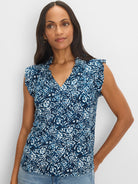 Blue & white shibori print knit top with a ruffled V-neck and soft, short sleeves, worn by a model.