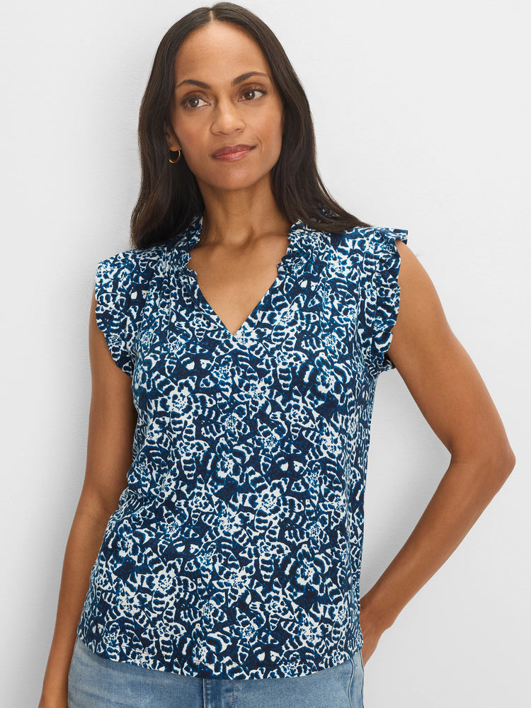 Blue & white shibori print knit top with a ruffled V-neck and soft, short sleeves, worn by a model.