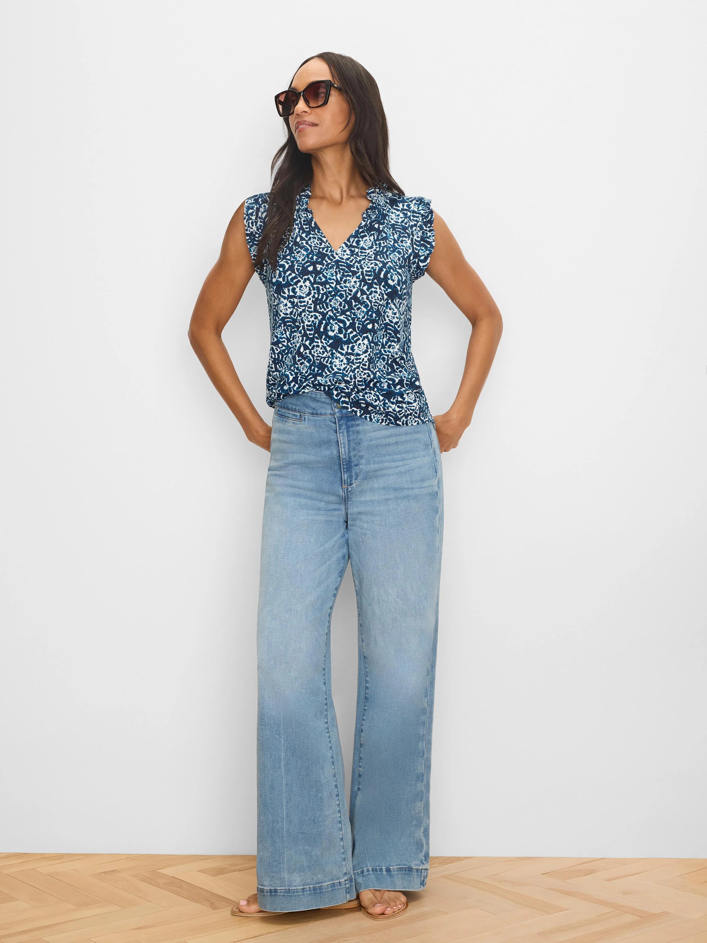 Navy V-neck top with white shibori lily pattern and soft, ruffled cap sleeves.