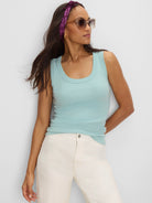 A light blue ribbed tank top with a scoop neck, shown form-fitting on a model.