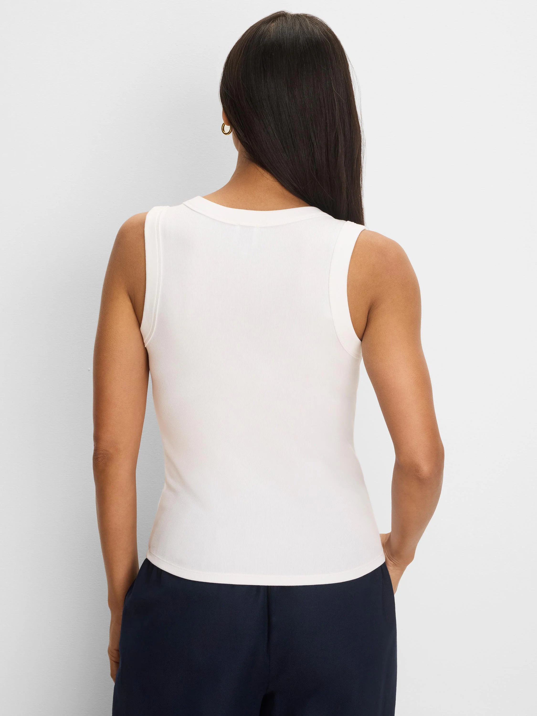 Cream rib-knit tank top, sleeveless, seen from the back on a model.