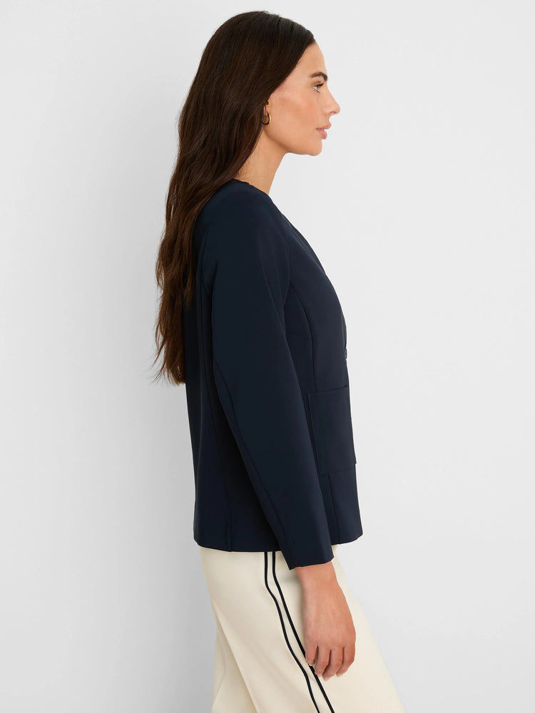 Dark navy collarless jacket with long sleeves, a smooth fit, and a single patch pocket on the side.
