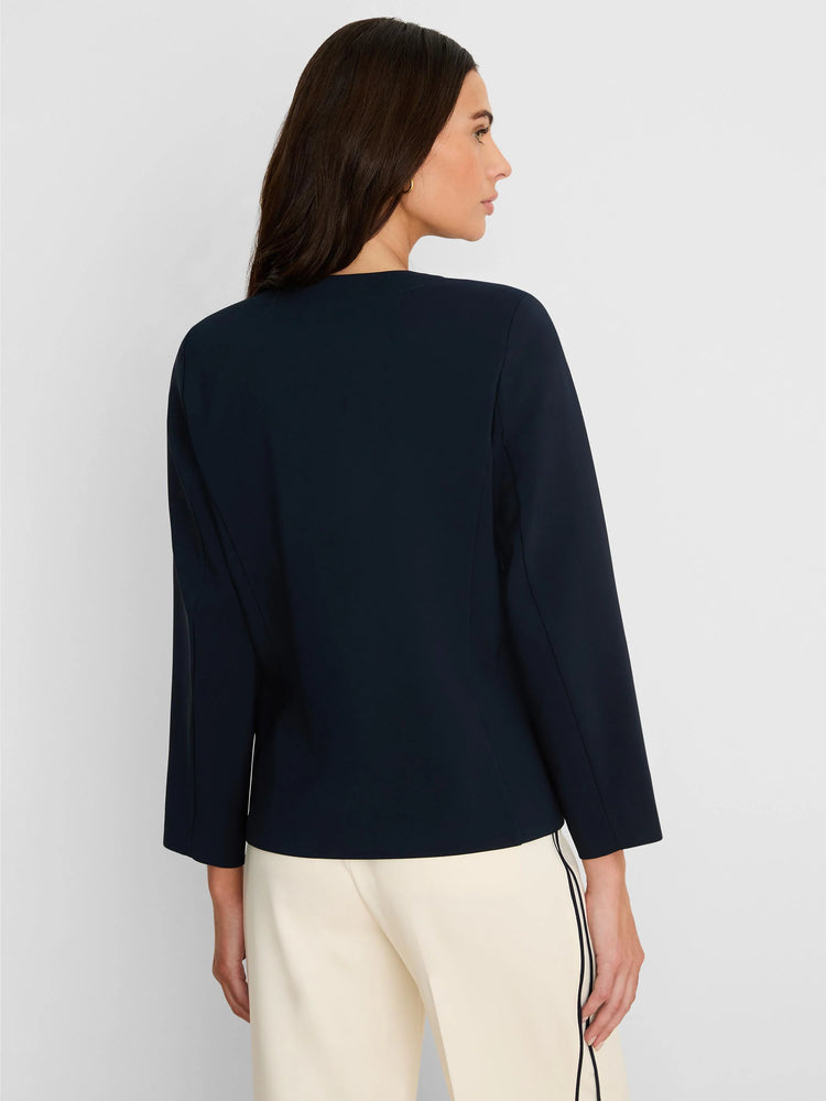 Navy collarless jacket with a sleek silhouette and 3/4 length sleeves.