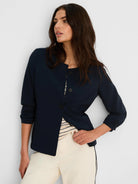 Navy collarless jacket with rounded neckline, three dark buttons, 3/4 sleeves, and two front pockets.