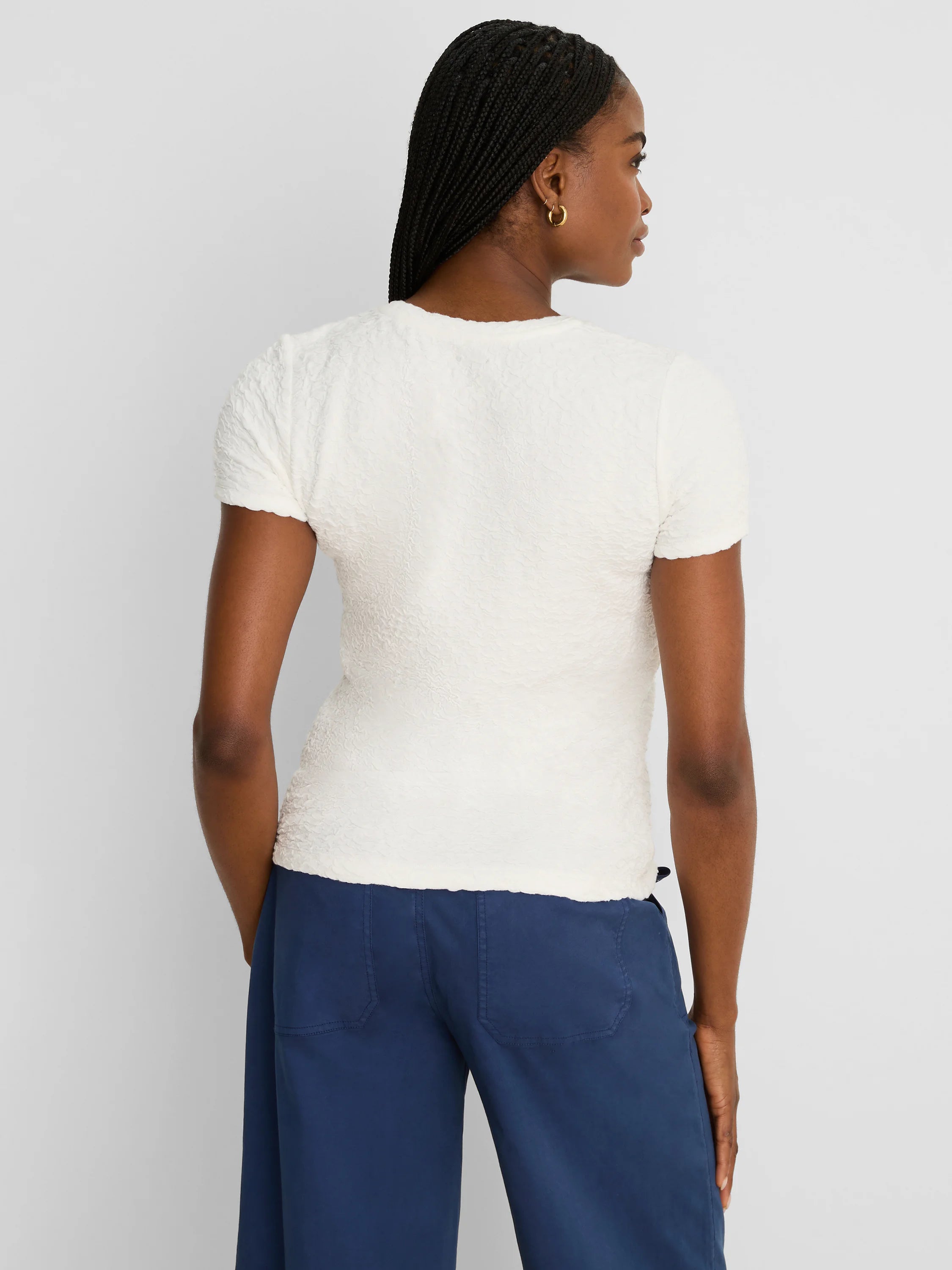 Off-white short-sleeve tee with a crinkled, puckered texture and round neck.
