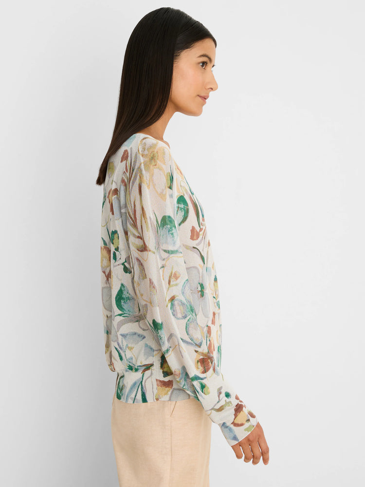 Cream sweater with a muted pressed flower print in shades of green, brown, yellow, and blue.