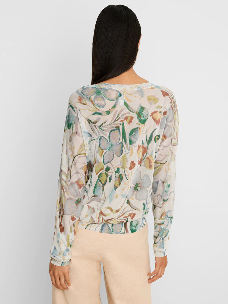 Off-white sweater with a pressed floral print in muted greens, blues, rust, and mauve. Long-sleeved, relaxed fit.
