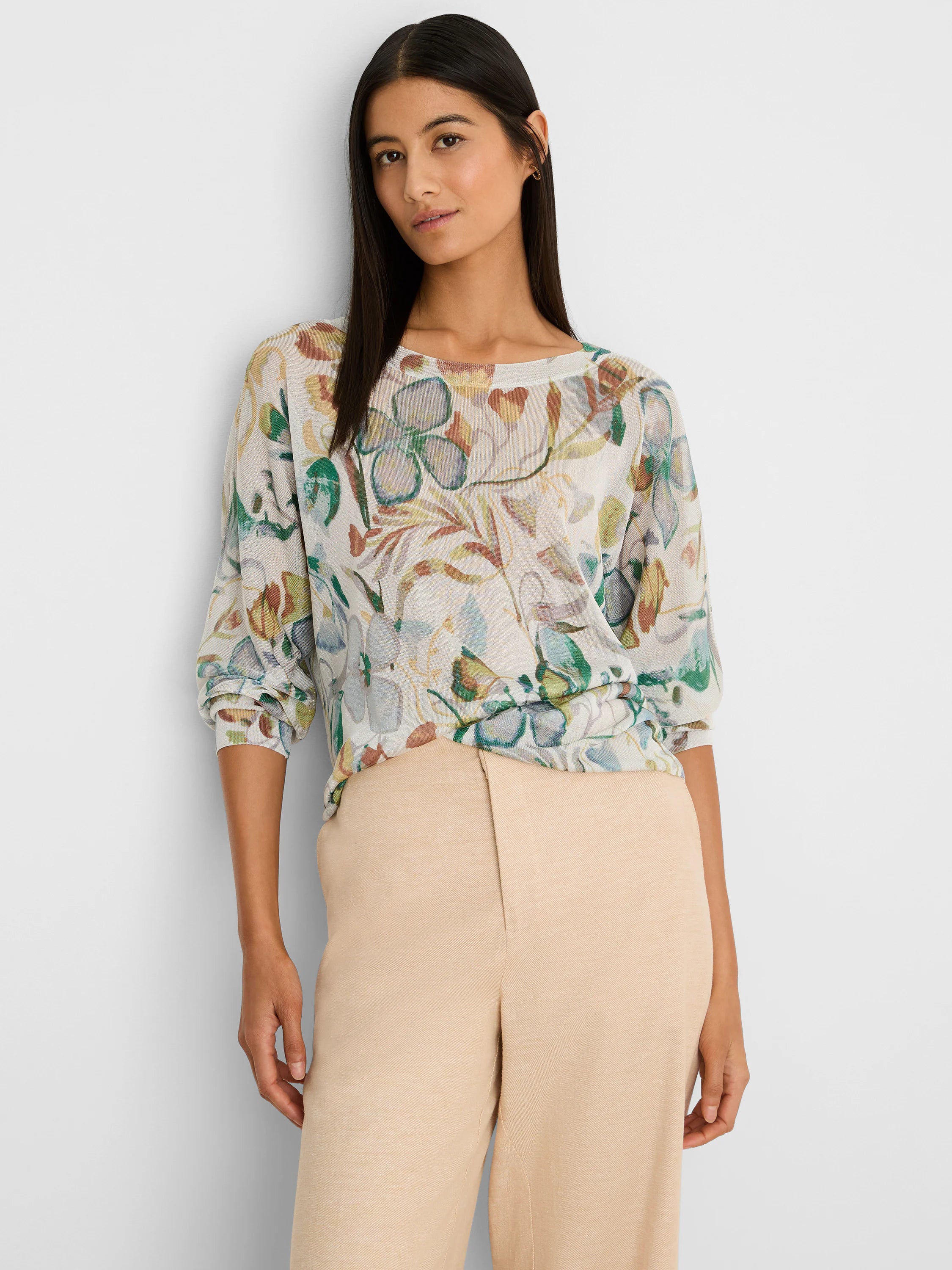 Cream boat neck sweater with an all-over pattern of muted pressed flowers in shades of green, blue, and rust.