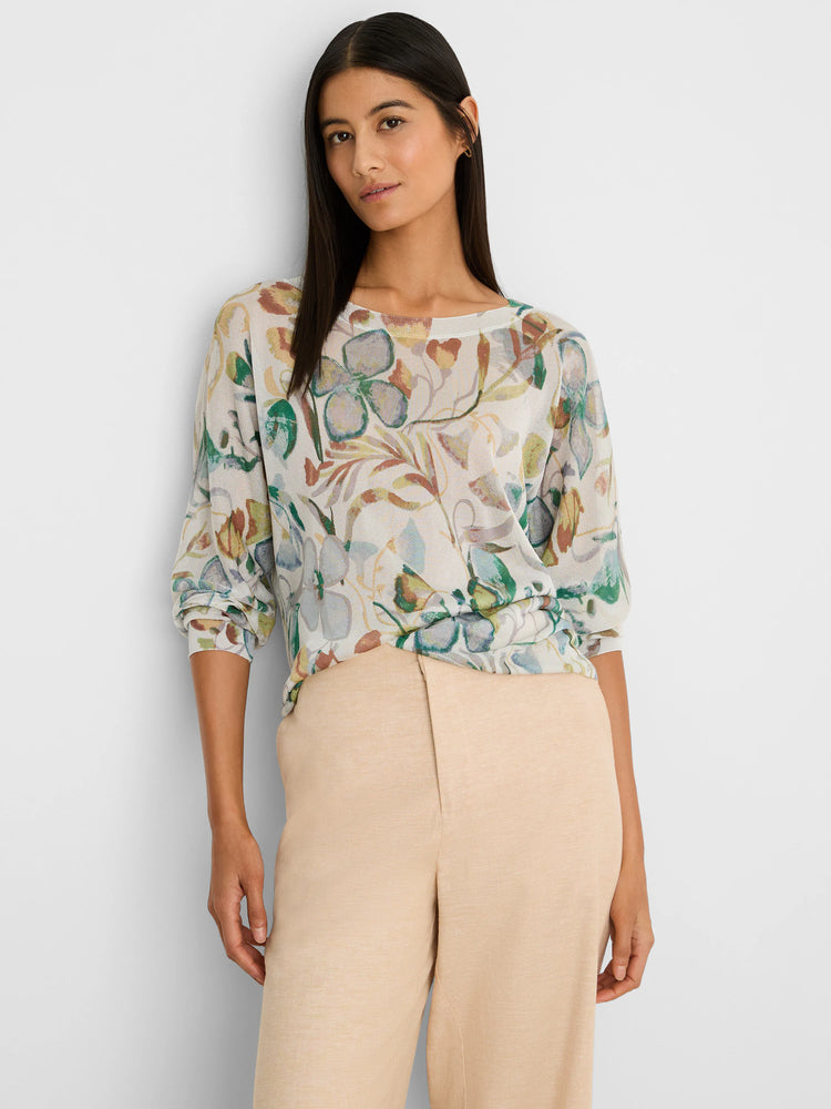 Cream boat neck sweater with an all-over pattern of muted pressed flowers in shades of green, blue, and rust.