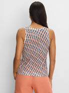 Sleeveless sweater tank with abstract navy, peach, and tan brushstroke pattern on a cream background.