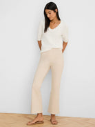 Cream textured knit sweater tee with a scalloped V-neckline and elbow-length sleeves.
