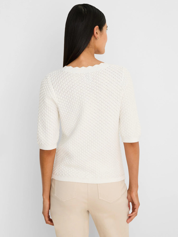 Back view of an off-white scallop-textured sweater tee. Features elbow-length sleeves and a scalloped neckline.