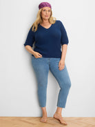 Dark blue sweater tee with an all-over textured knit, scalloped neckline, and elbow-length sleeves.