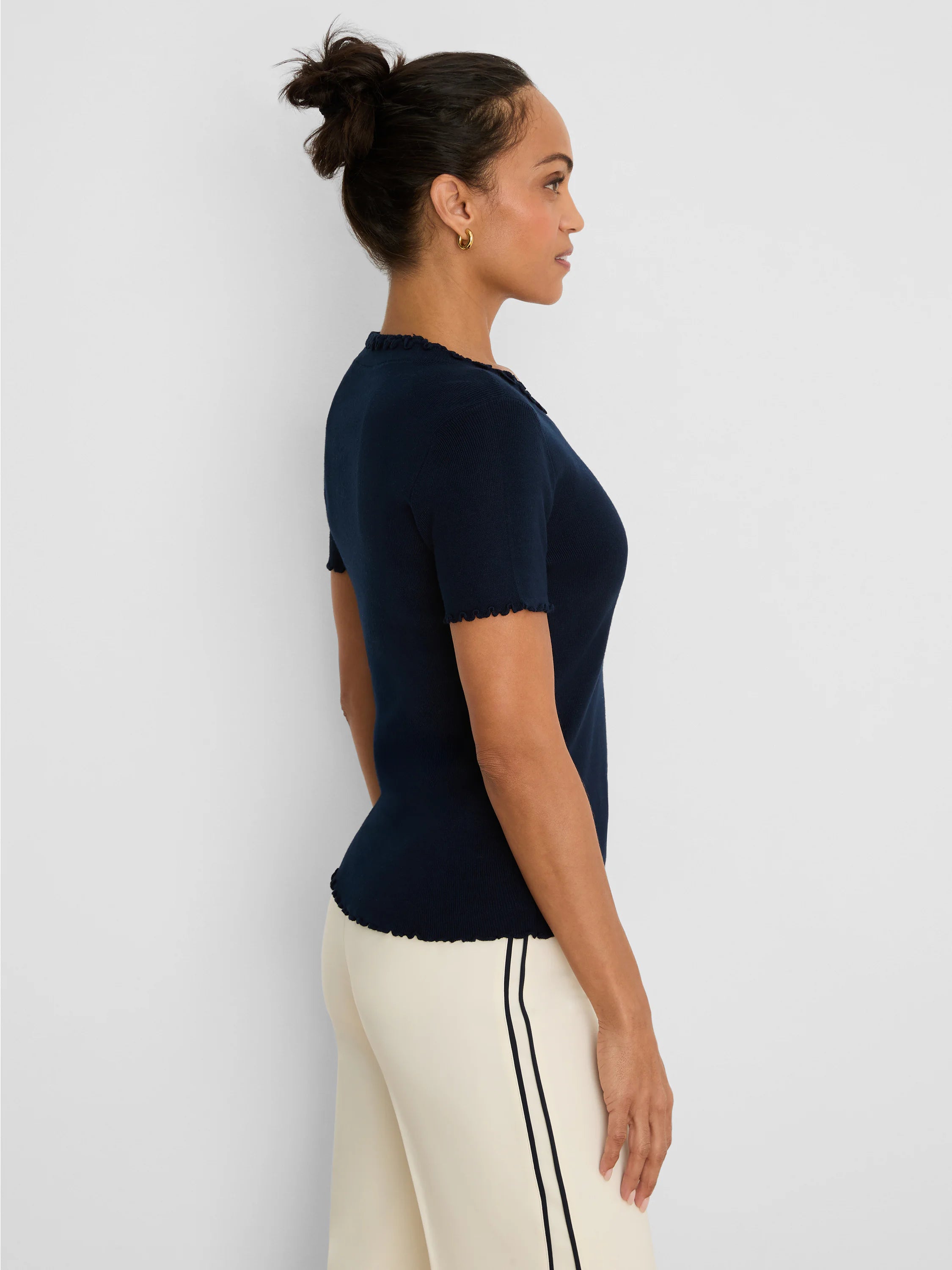 Navy blue short-sleeve ribbed sweater tee with ruffle trim on the neckline, sleeves, and bottom hem.