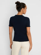 Dark blue ribbed sweater tee with short sleeves and ruffle trim on the neck, sleeve cuffs, and bottom hem.