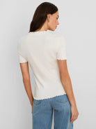 Off-white ribbed short-sleeve tee with ruffles on the high neckline, sleeve cuffs, and bottom hem.
