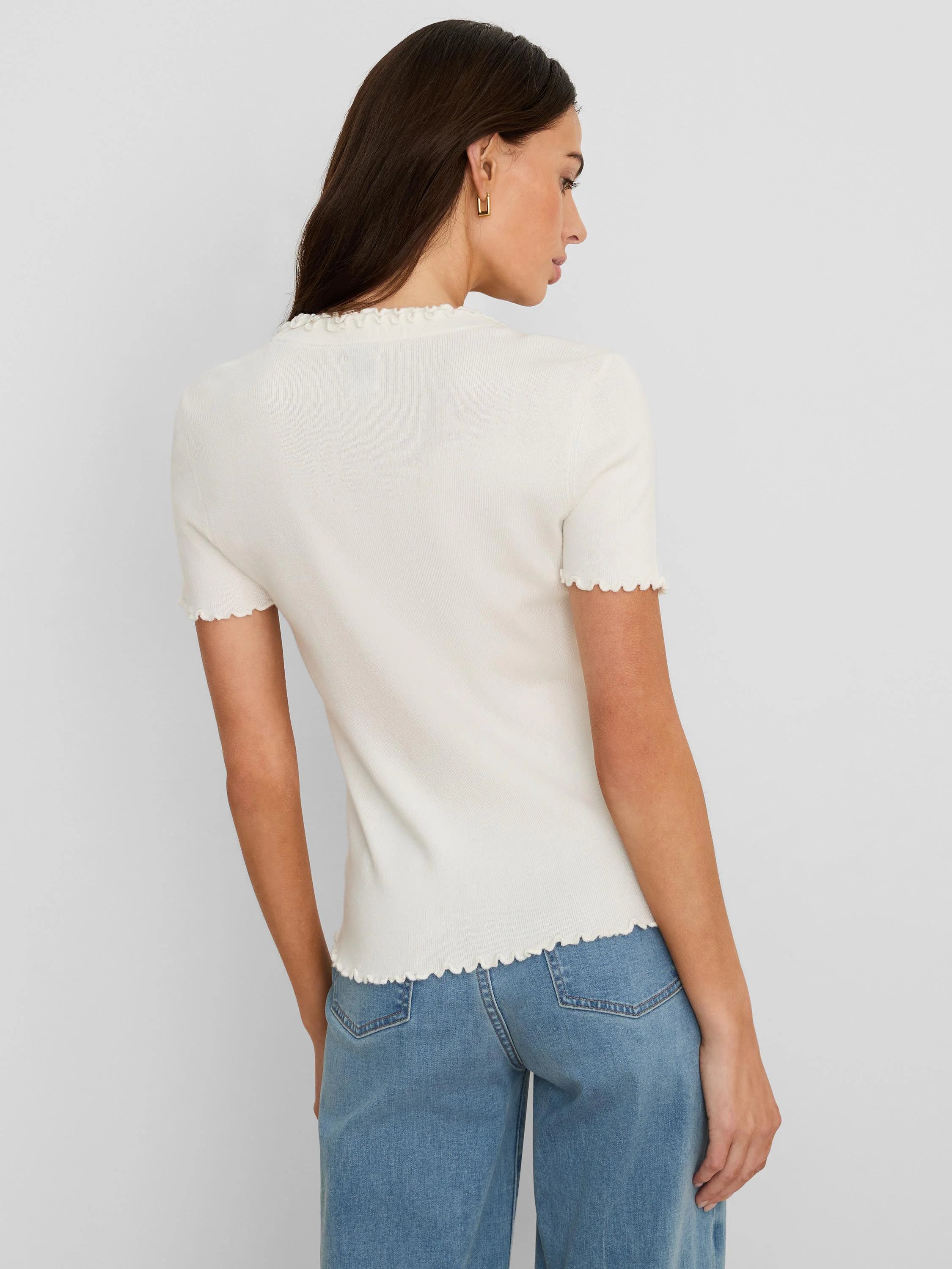 Off-white ribbed short-sleeve tee with ruffles on the high neckline, sleeve cuffs, and bottom hem.