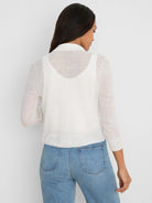 White featherknit collared cardigan, sheer with 3/4 sleeves. Model from behind.
