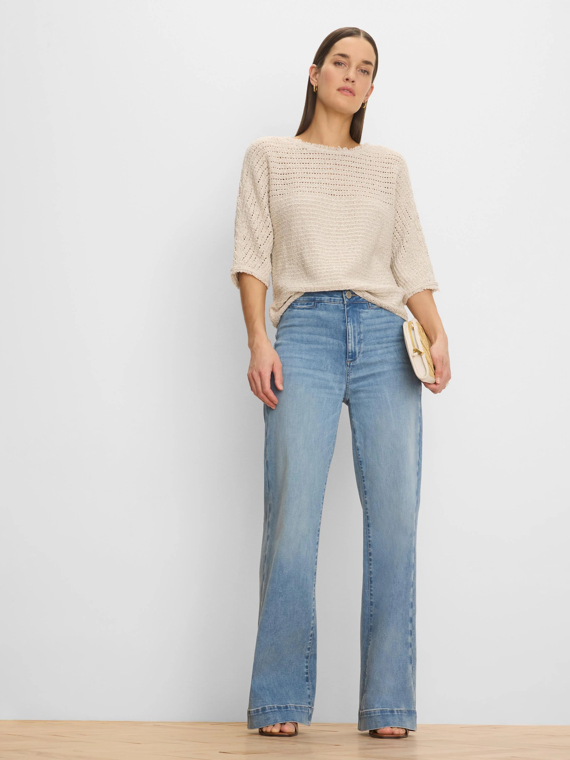 Loose beige open-knit sweater with varied textures, 3/4 sleeves, and a wide neckline.
