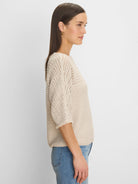 Light beige tonal texture sweater. Features include open knit patterns on shoulders/sleeves & fringed 3/4 cuffs.