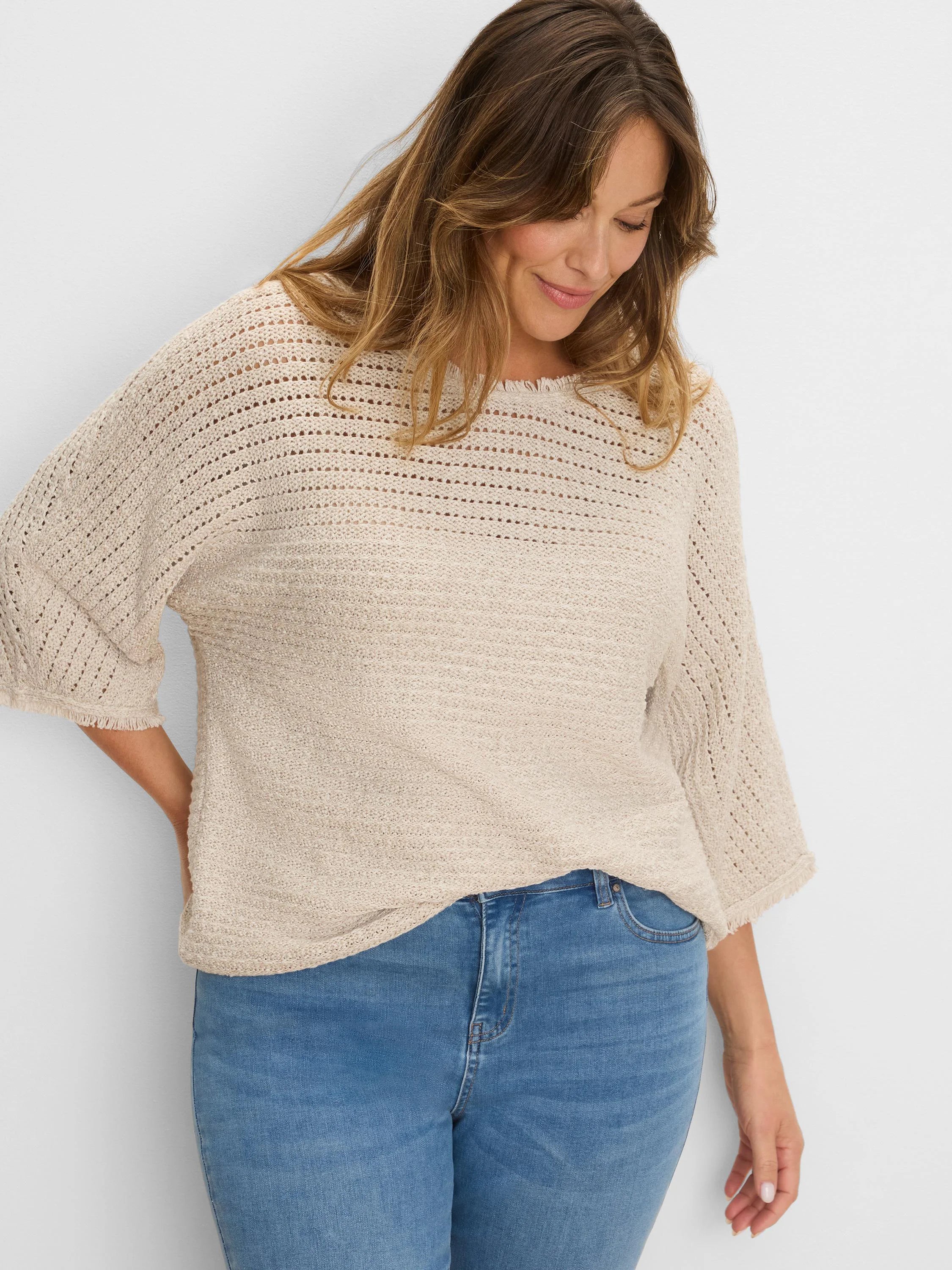 Light beige sweater with varied open-knit upper and dense body, 3/4 sleeves, and fringed edges.