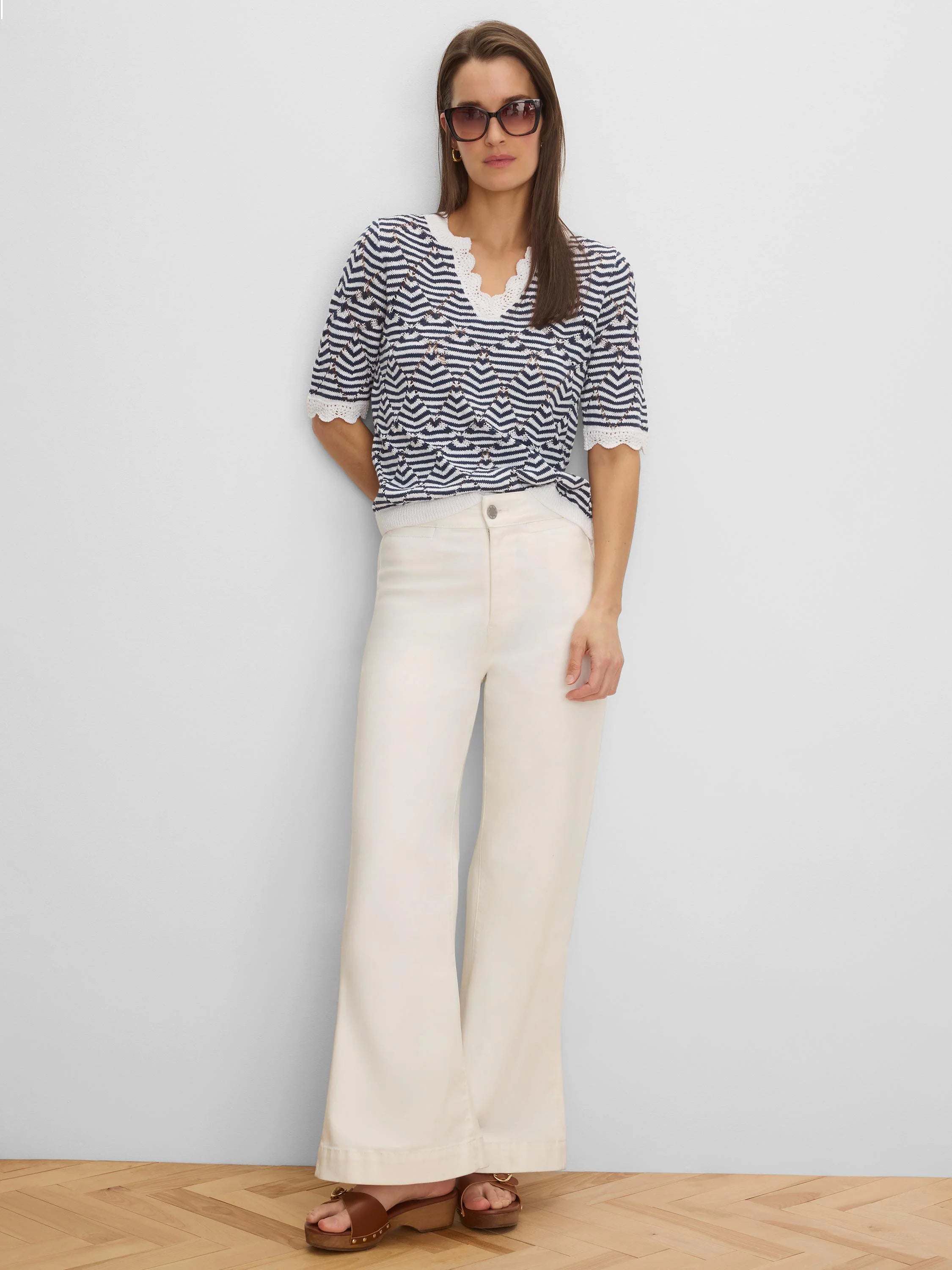 Short-sleeved navy and white zigzag knit sweater with V-neck and white lace trim.