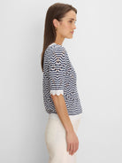 Navy and white chevron sweater with short, scalloped sleeves and an open knit.