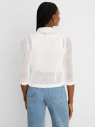 White mesh knit cardigan with a mock neck, 3/4 sleeves, and ruffled cuffs/hem, shown from the back.
