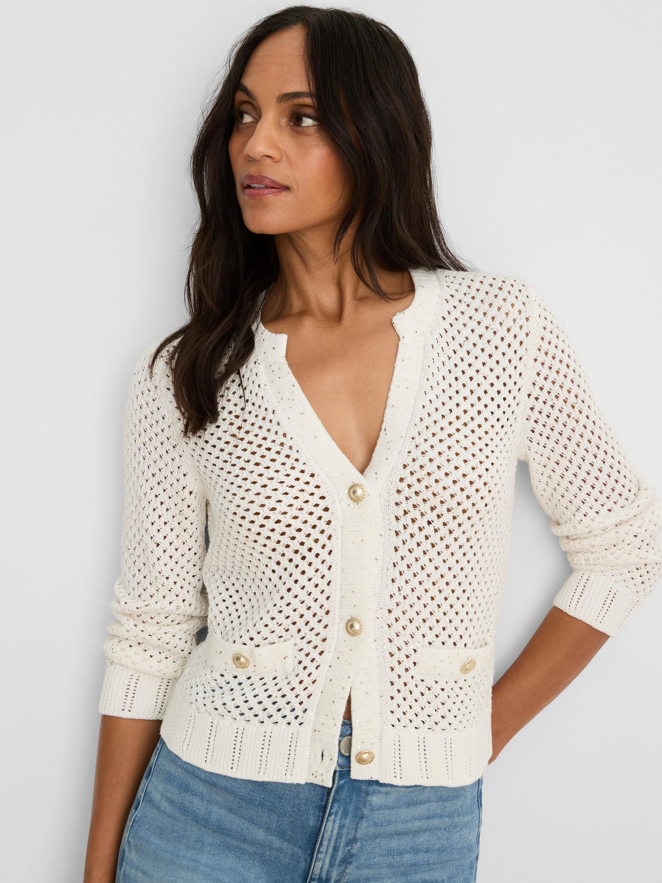Cream open-knit V-neck cardigan with subtle sequins, gold buttons, and ribbed cuffs/hem.