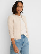 Light beige open-front knit jacket with chevron pattern, scallop trim, and patch pockets.