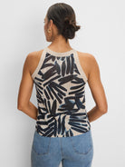 Beige knit tank with dark blue painted palm pattern. Ribbed beige neck and armholes. Back view.