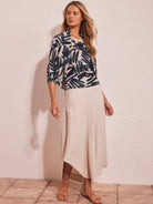 Cream bolero cardigan with navy abstract palm print. Features an open front and draped 3/4 sleeves.