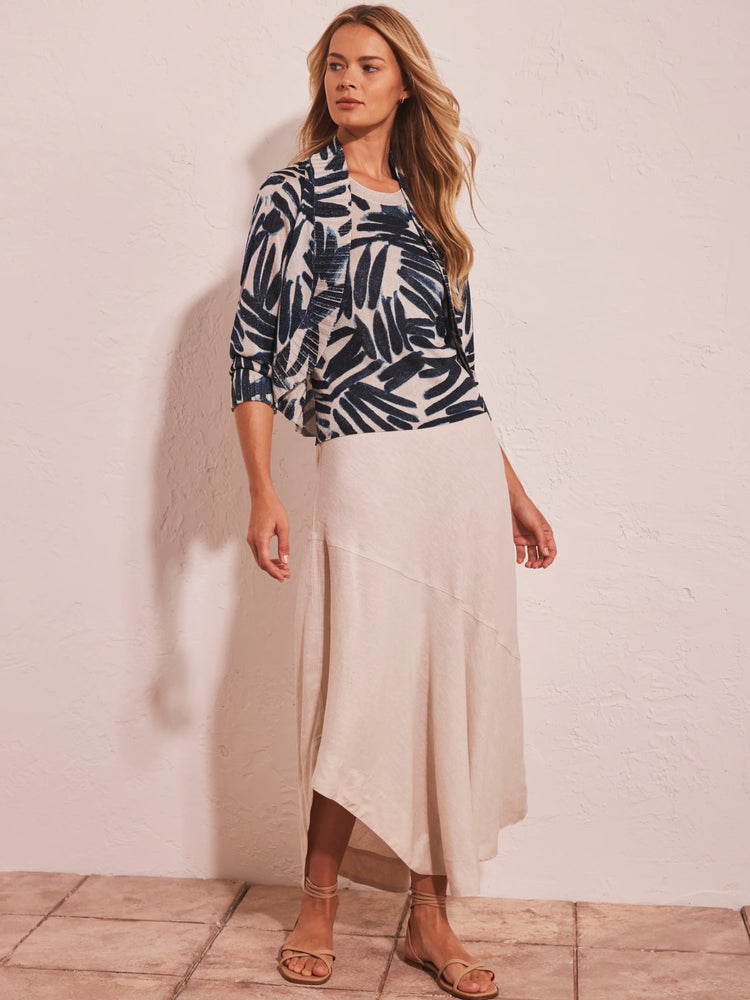 Cream bolero cardigan with navy abstract palm print. Features an open front and draped 3/4 sleeves.