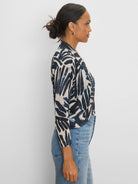 Beige bolero cardigan with brushstroke-style navy palm print, long sleeves.