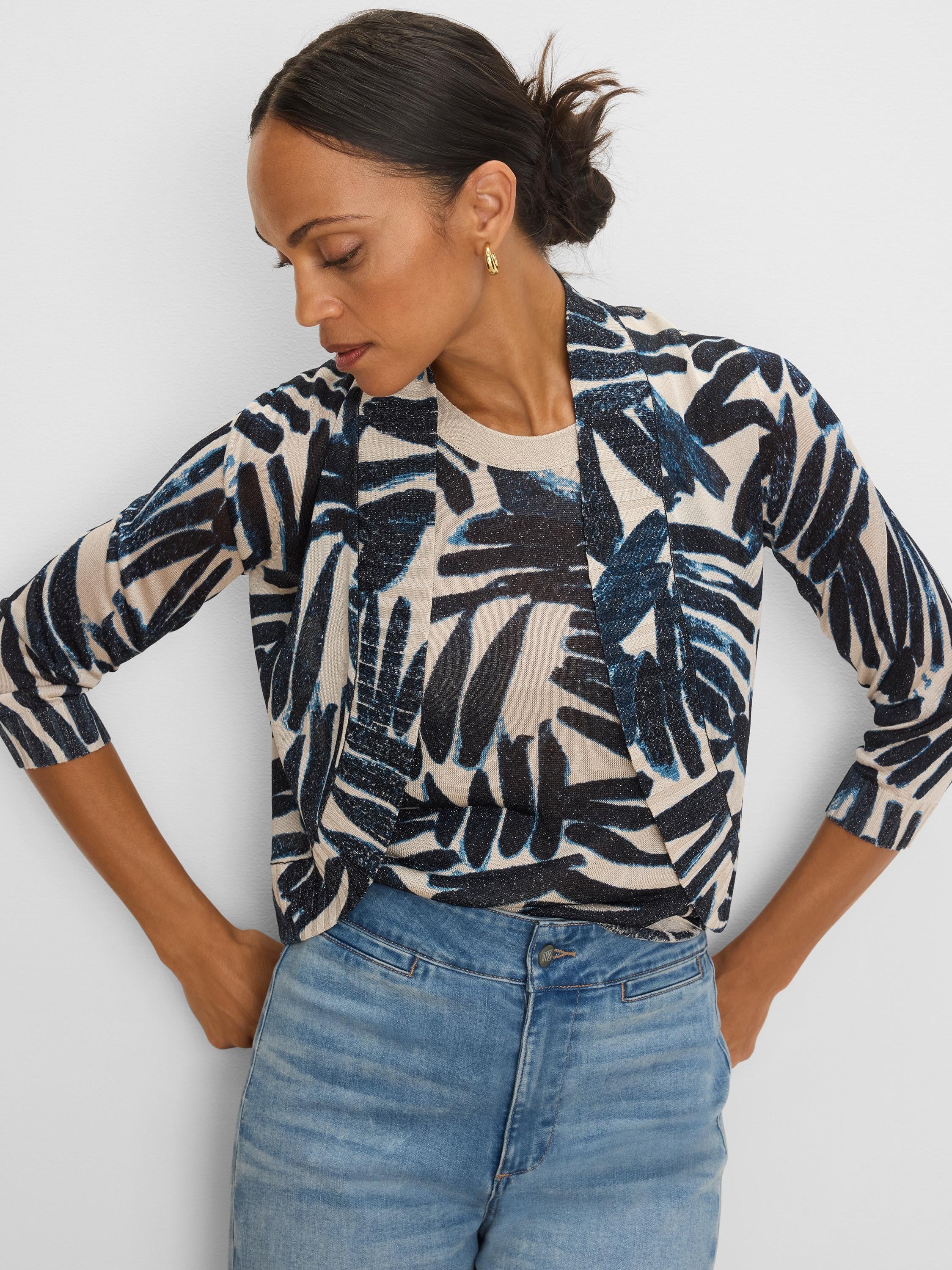 Bolero cardigan, beige knit with 3/4 sleeves, featuring a shimmering abstract dark blue and black palm print.