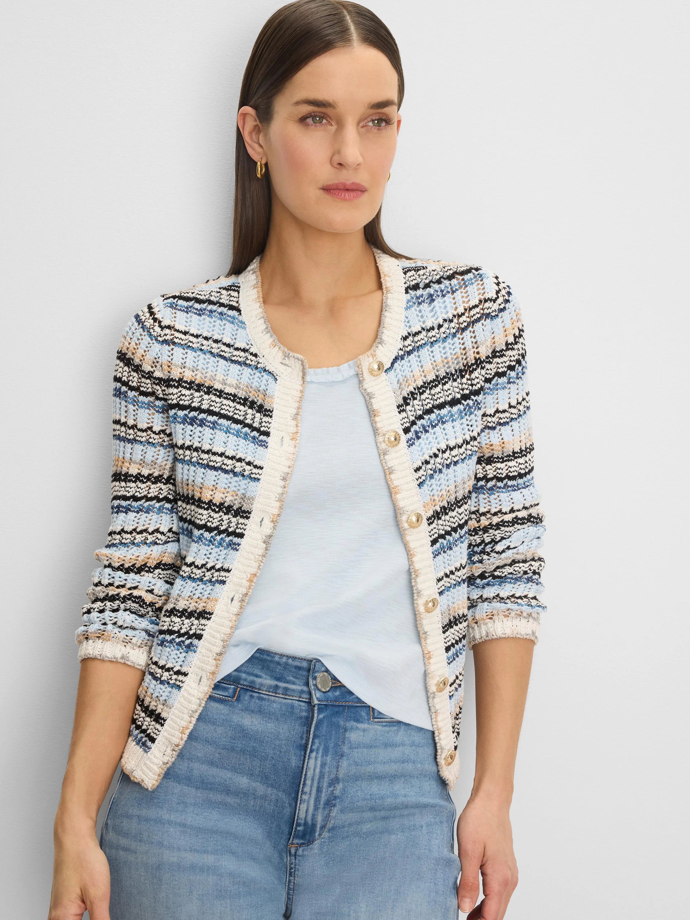 Wavy knit cardigan in shades of blue, black, tan, and white, with gold buttons and cream trim.